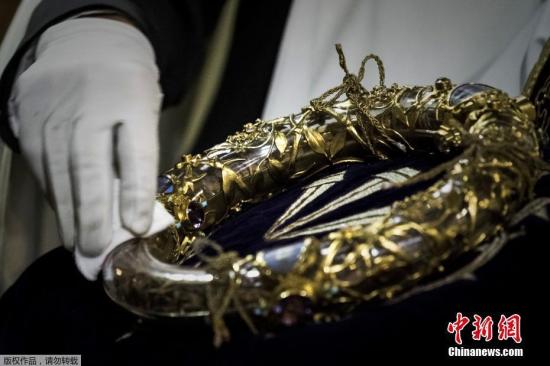 当地时间4月15日晚,法国著名的巴黎圣母院起火。在大火中,大教堂著名的尖塔坠落,内部损伤严重。根据最新消息,巴黎圣母院祭坛和十字架在火灾中幸存,包括荆棘王冠在内的部分珍贵文物获救。图为一名牧师在擦拭荆棘王冠。(资料图) 点击进入下一页